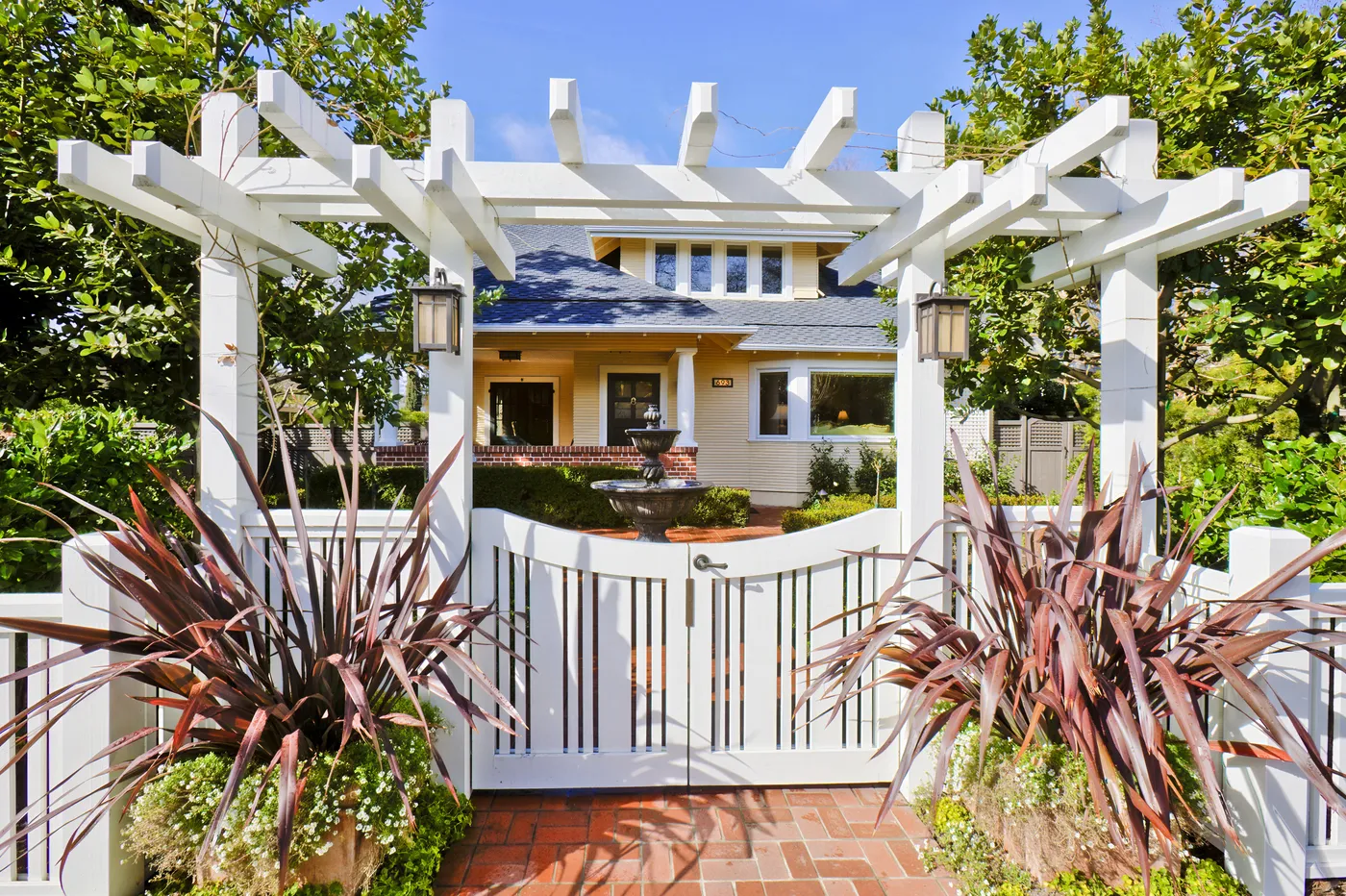 White timber arbor and gate framing the path to the house