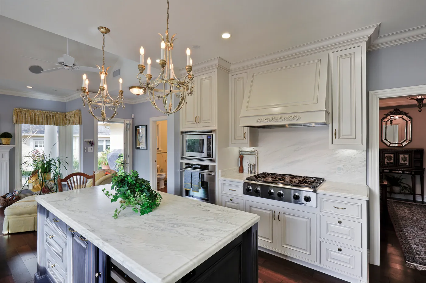 Range below a painted tile panel, set into a plaster hood surround