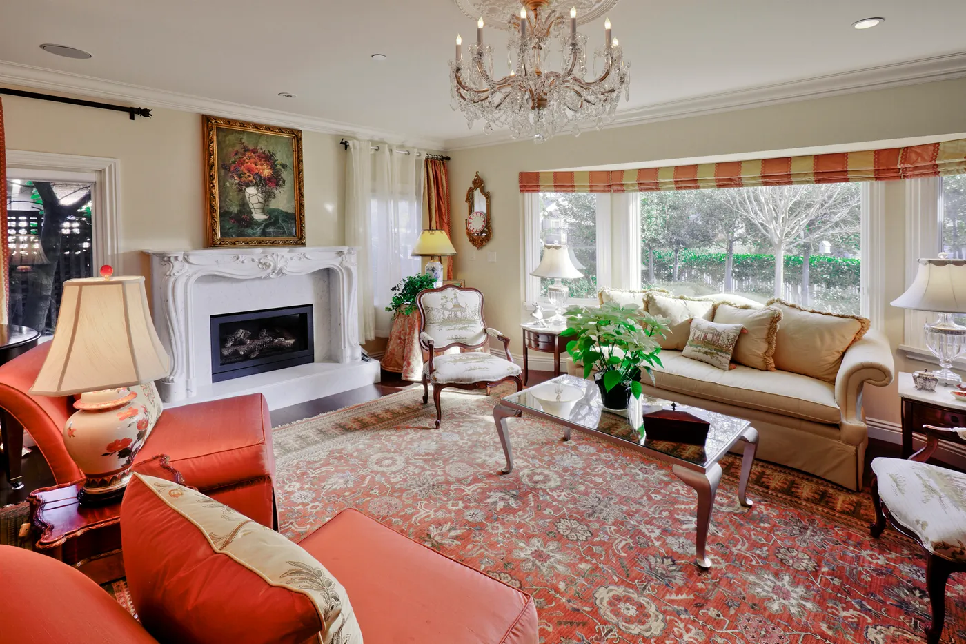 Living room with a carved marble fireplace and a bay window to the garden