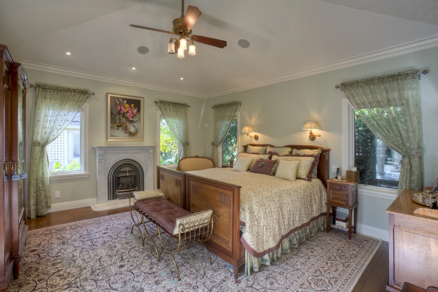 Principal bedroom with a marble fireplace and curtained windows on two sides