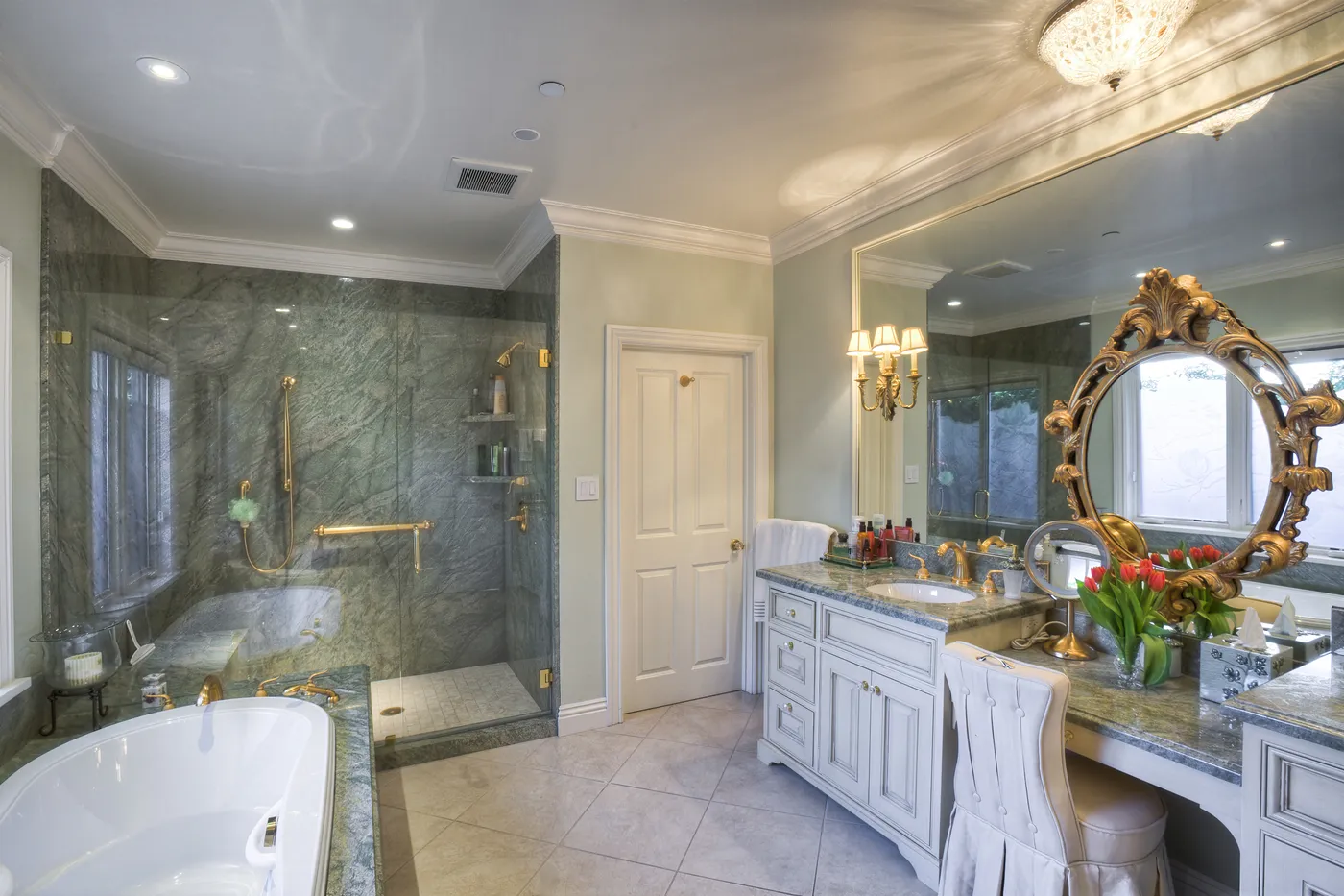 Principal bath in green marble, walk-in shower beside a vanity and dressing table