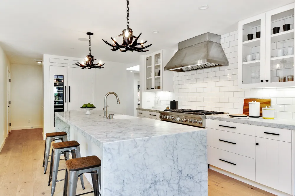 Kitchen with a marble island and paneled cabinetry