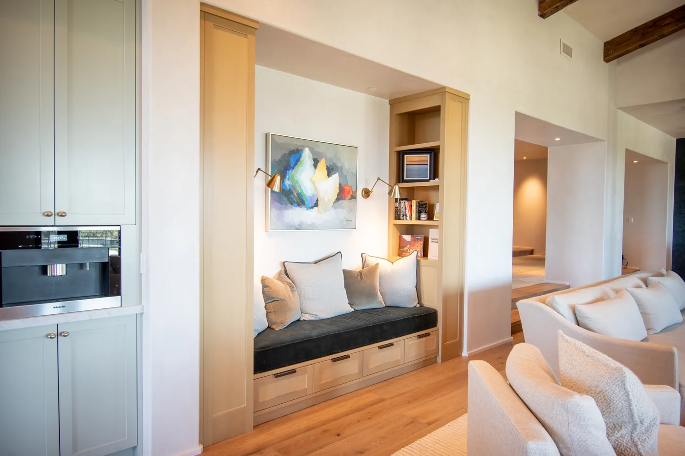 Built-in window seat beside the kitchen cabinetry, open to the living room