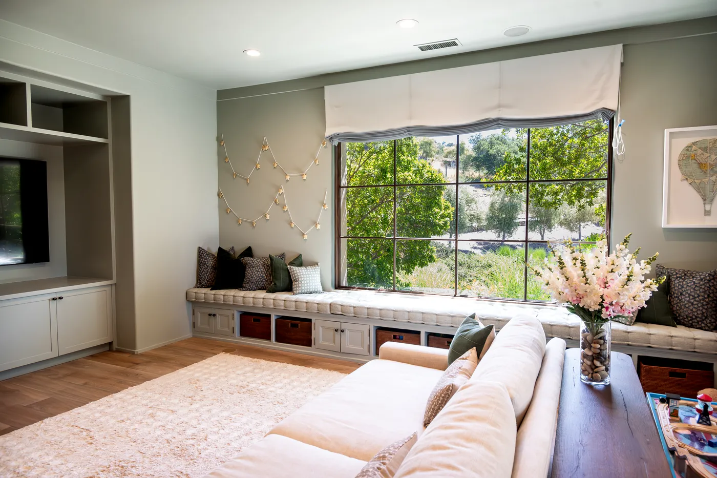 Family room with a long window seat and built-in storage below a garden window