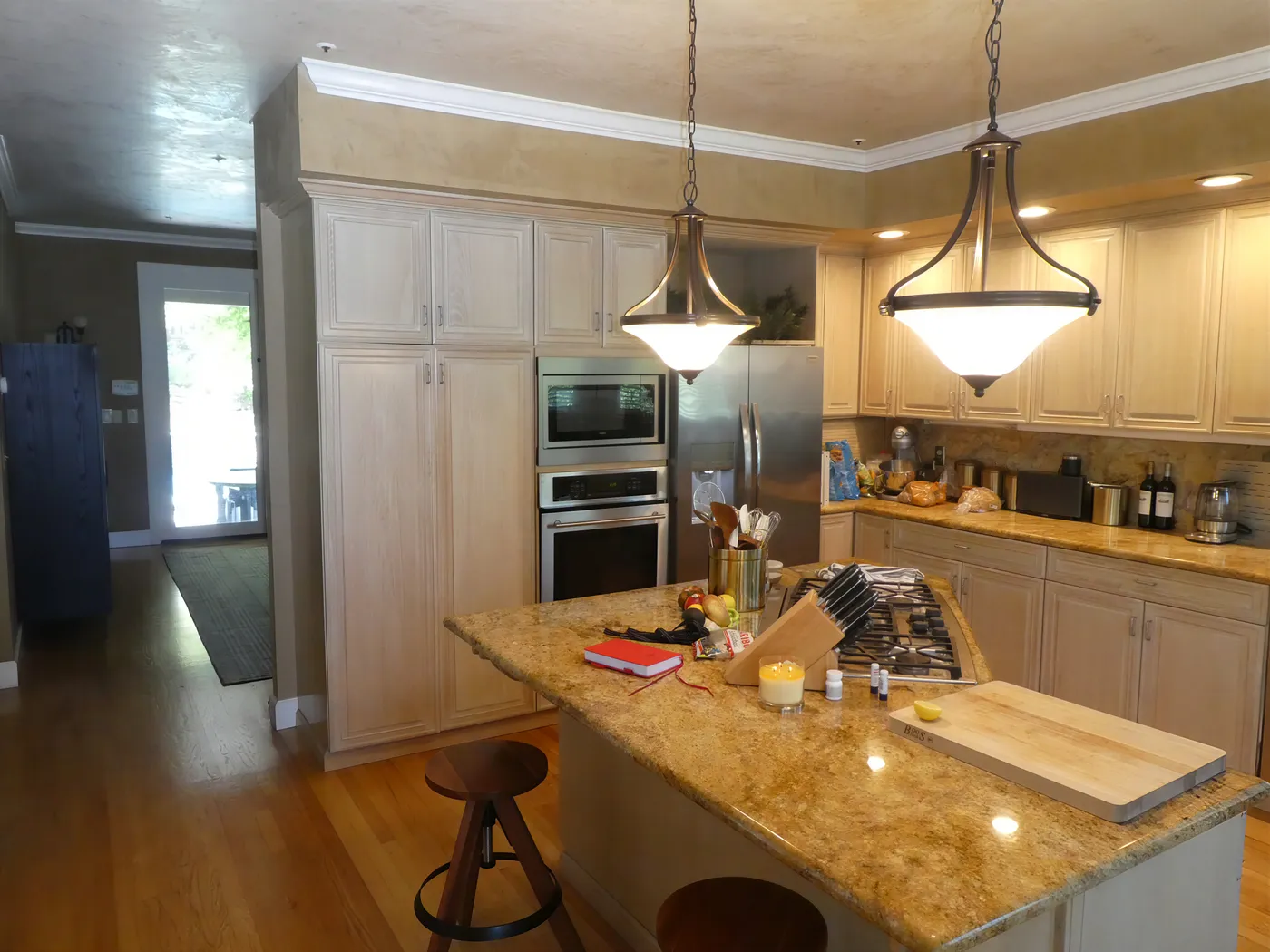 The kitchen before the remodel — the original cabinet wall with a wall oven and refrigerator
