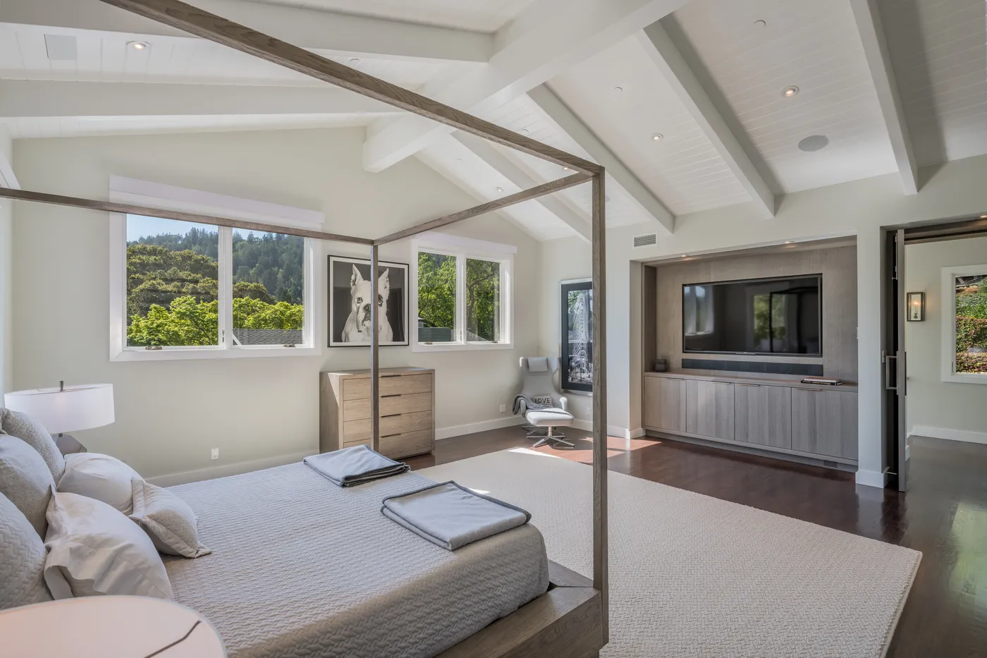 Principal bedroom with a metal canopy bed and windows to the hills