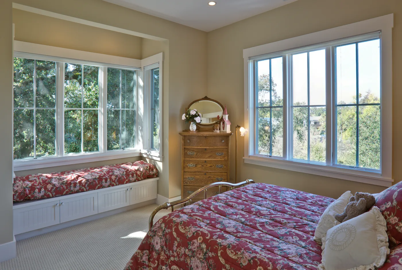 Bedroom with a window seat built into the bay and an iron bed