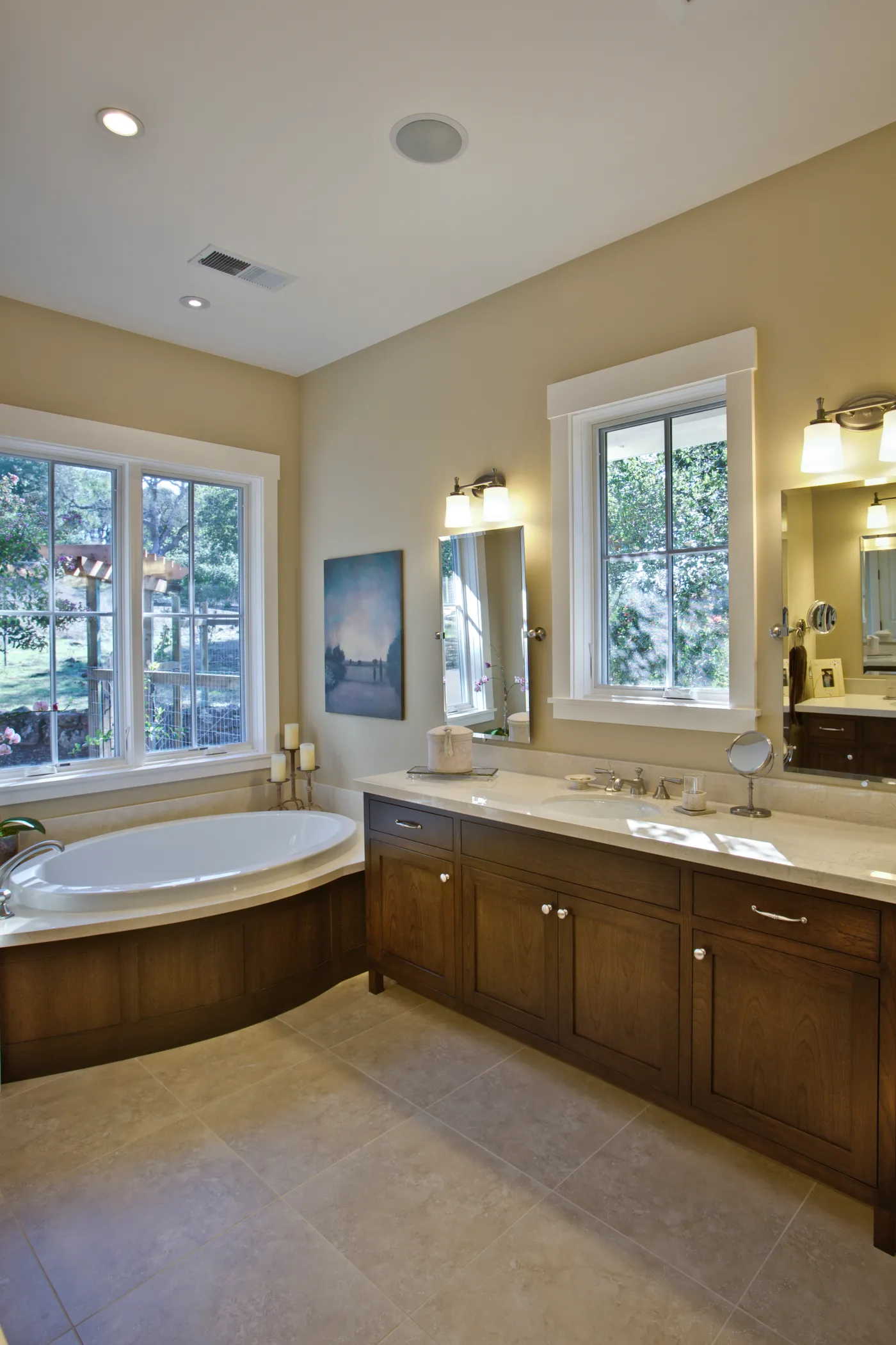 Primary bath with a corner tub below the windows and a timber vanity