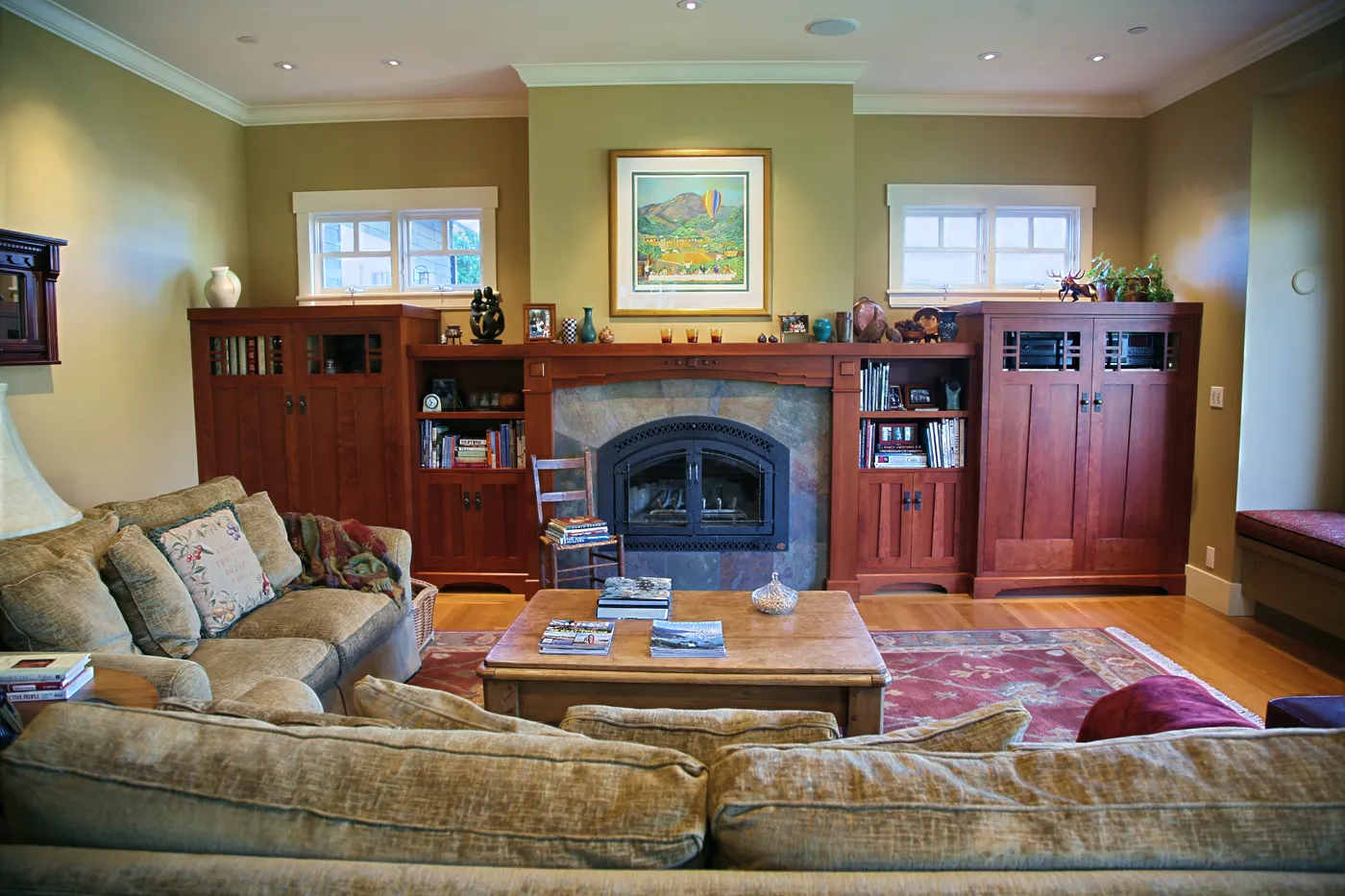 Living room with a slate fireplace flanked by built-in cabinets and bookshelves
