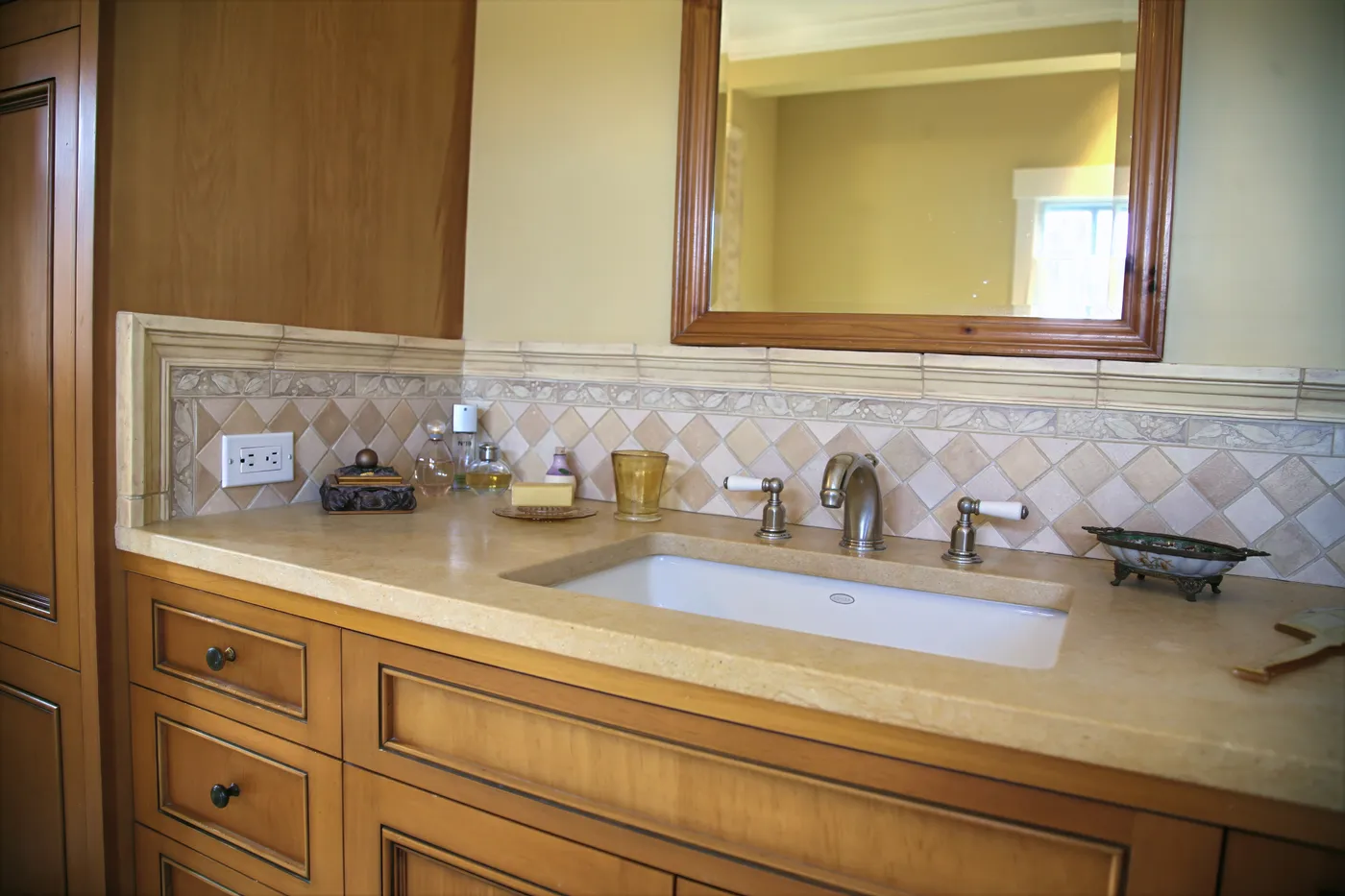 Vanity with an undermount sink, stone top and a diamond-set tile backsplash