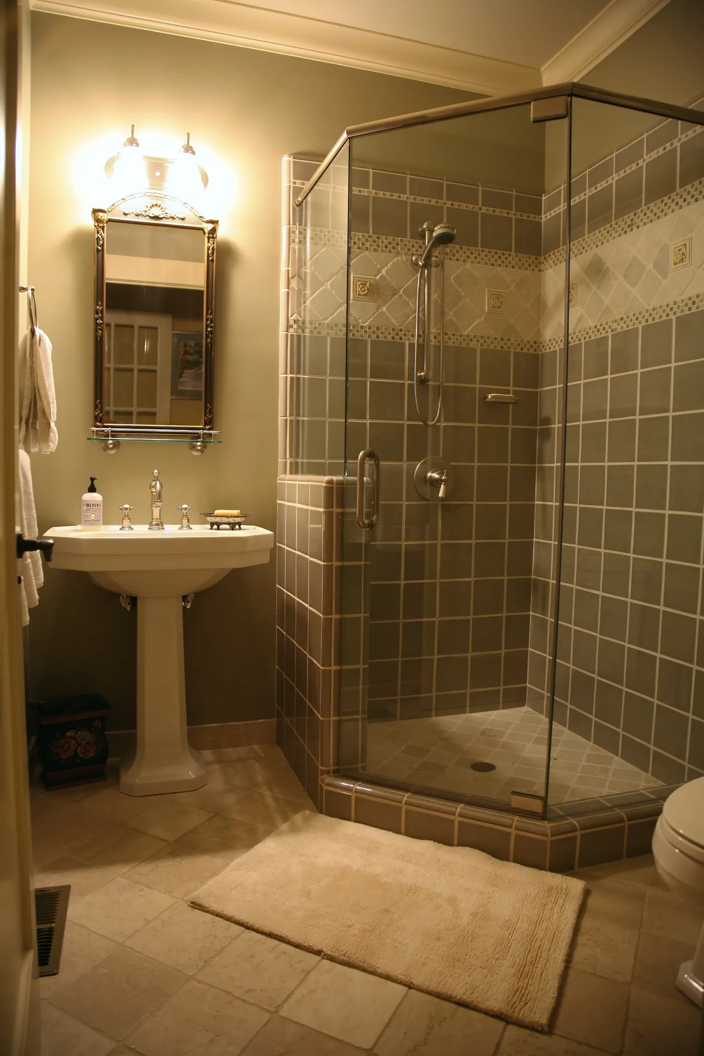 Guest bath with a pedestal sink and a neo-angle glass shower tiled to the ceiling