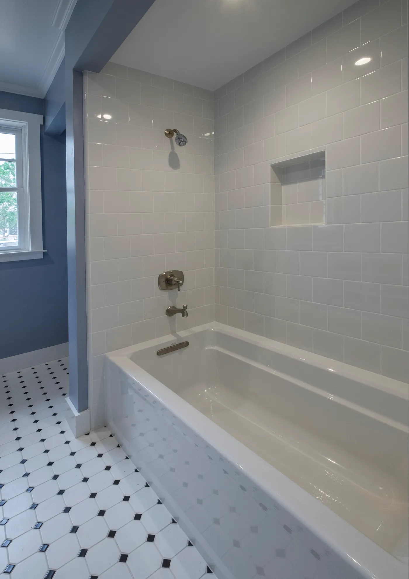 Guest bath with a subway-tiled tub and shower and an octagon tile floor