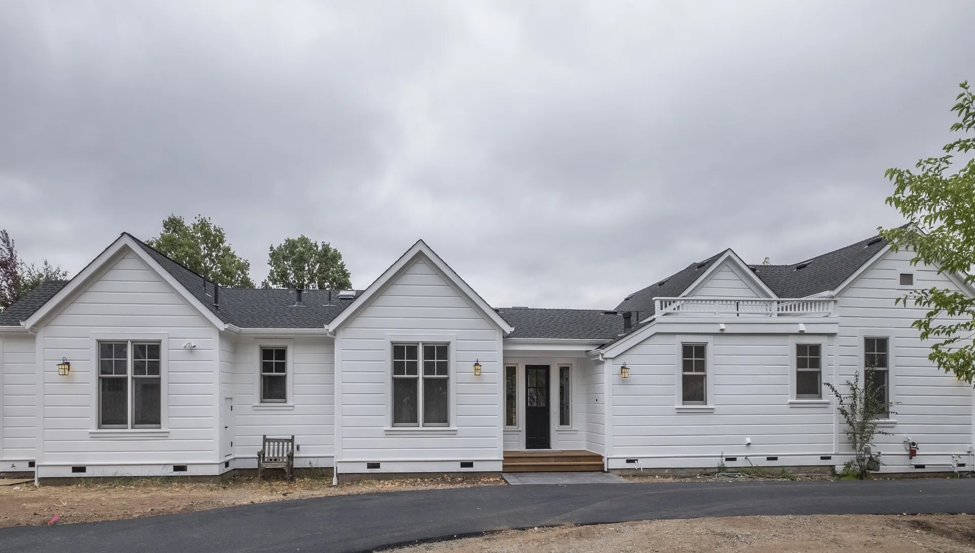 The remodeled white farmhouse from the front garden