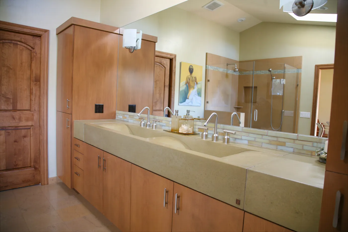 Primary bath with a poured concrete trough vanity below a long mirror