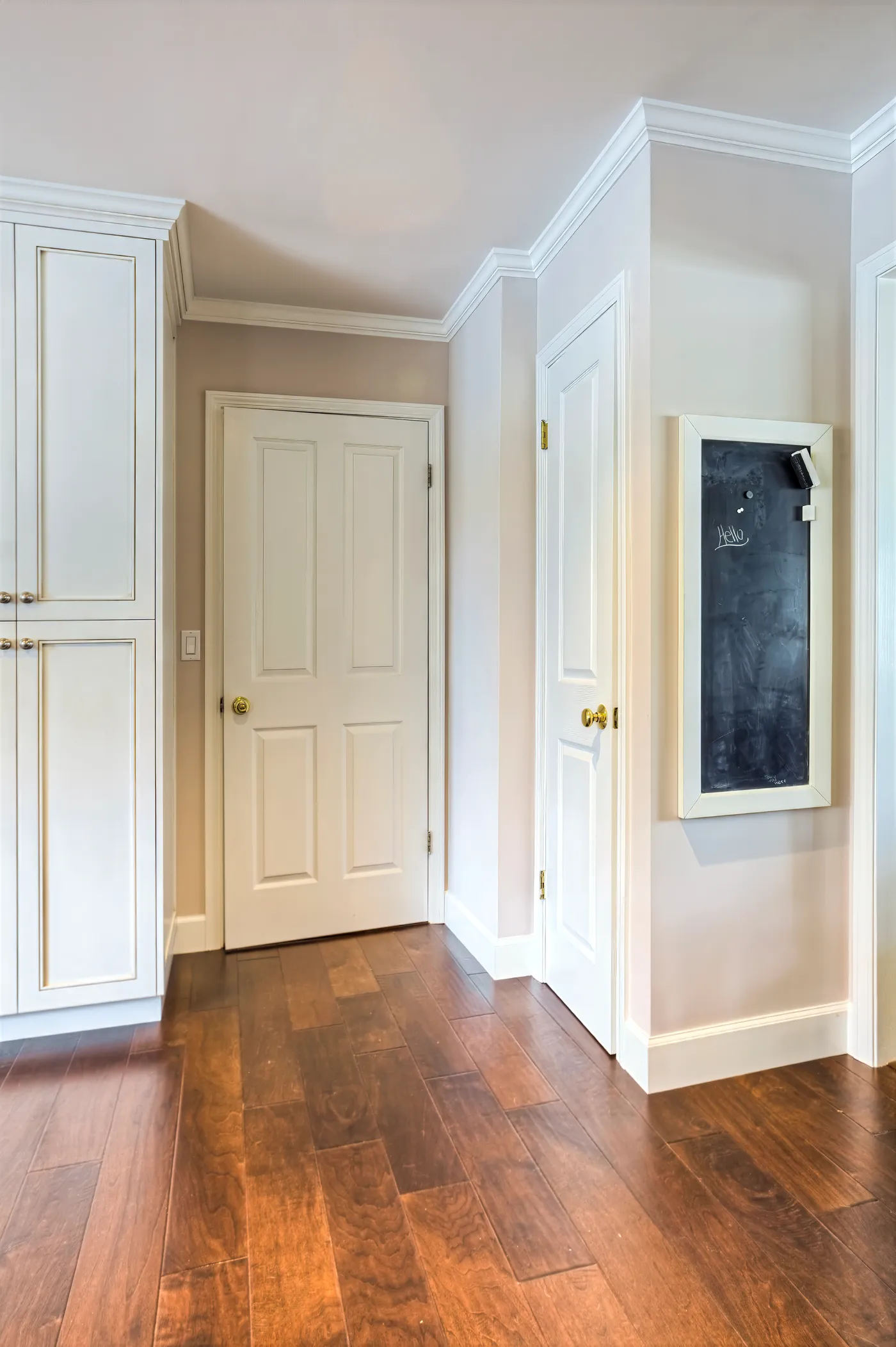 Panelled doors off the kitchen with a chalkboard hung between them