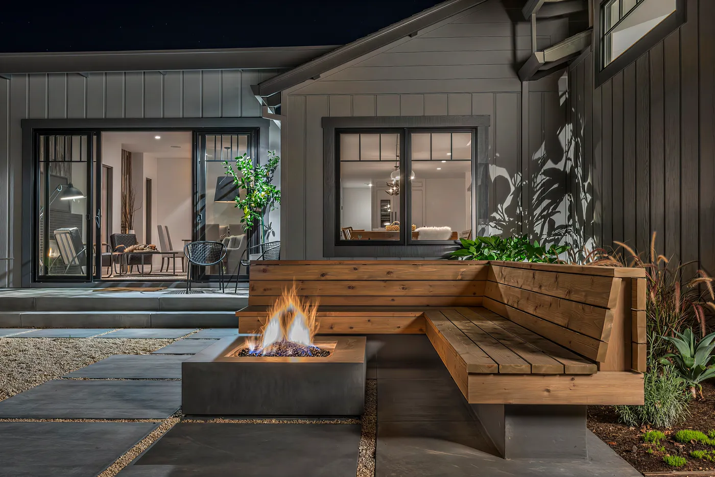 Gas fire table and built-in timber bench in the courtyard at night