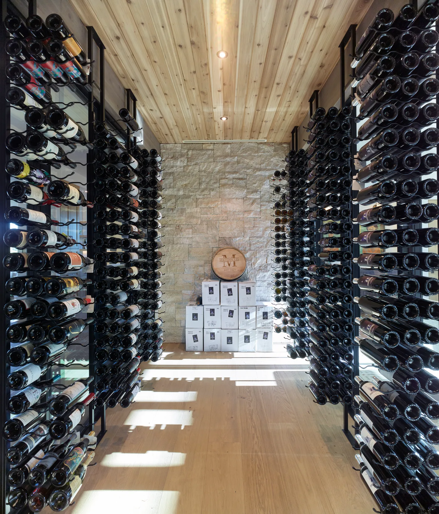 Wine room with floor-to-ceiling racking under a cedar ceiling