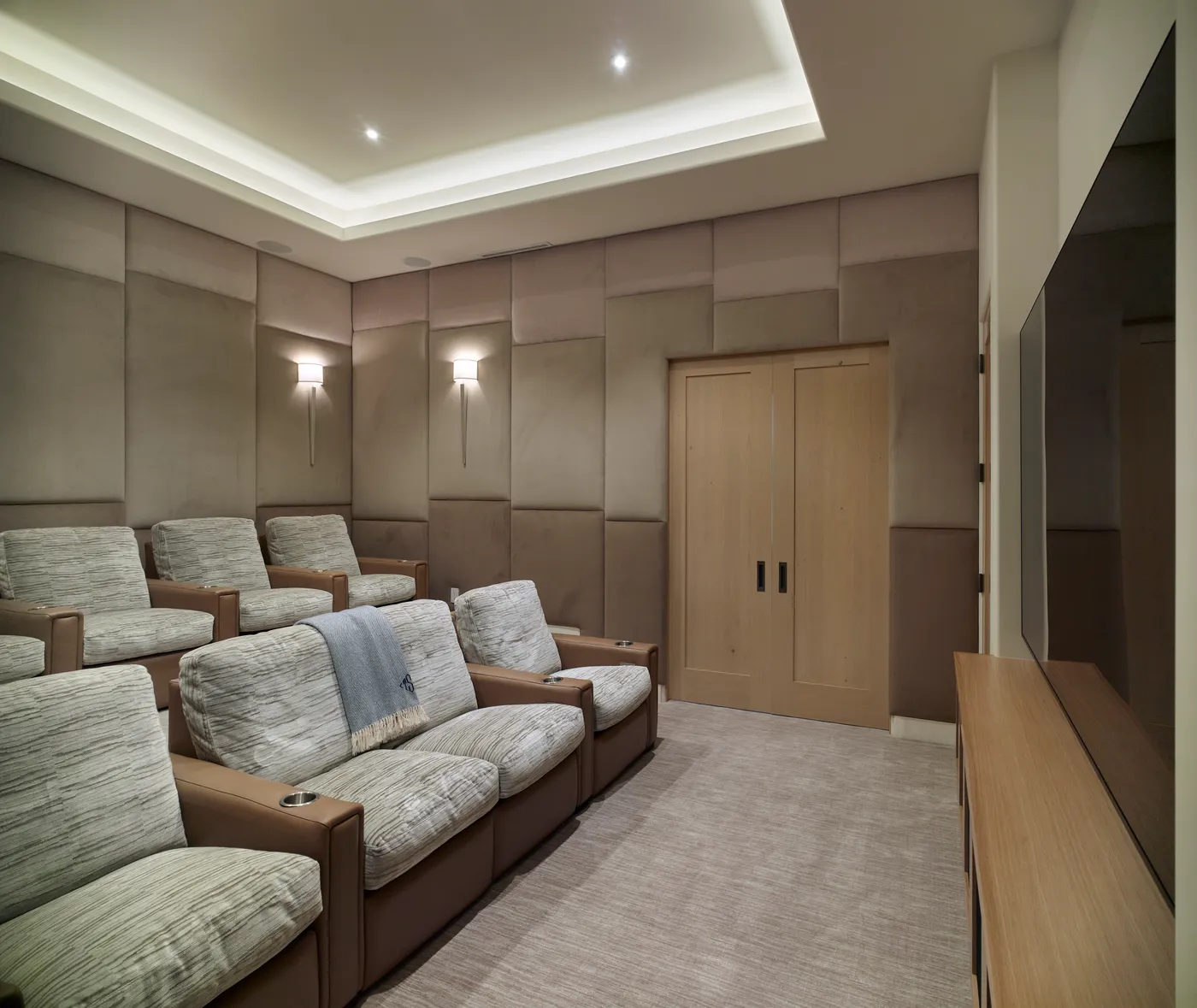Home theater with tiered recliners and padded wall panels