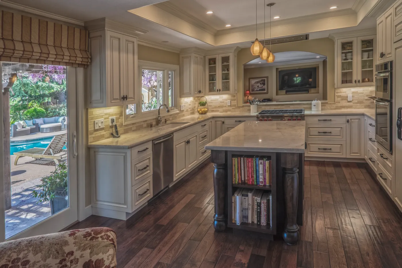 Kitchen with a walnut island, glazed doors to the pool terrace beyond