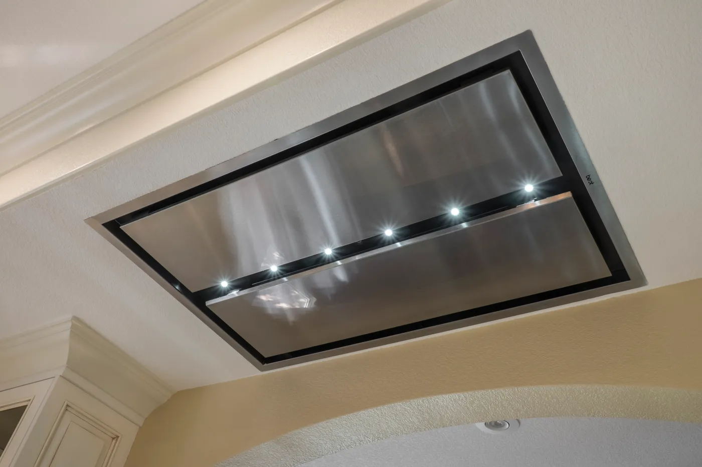 Flush stainless extract hood set into the ceiling above the range