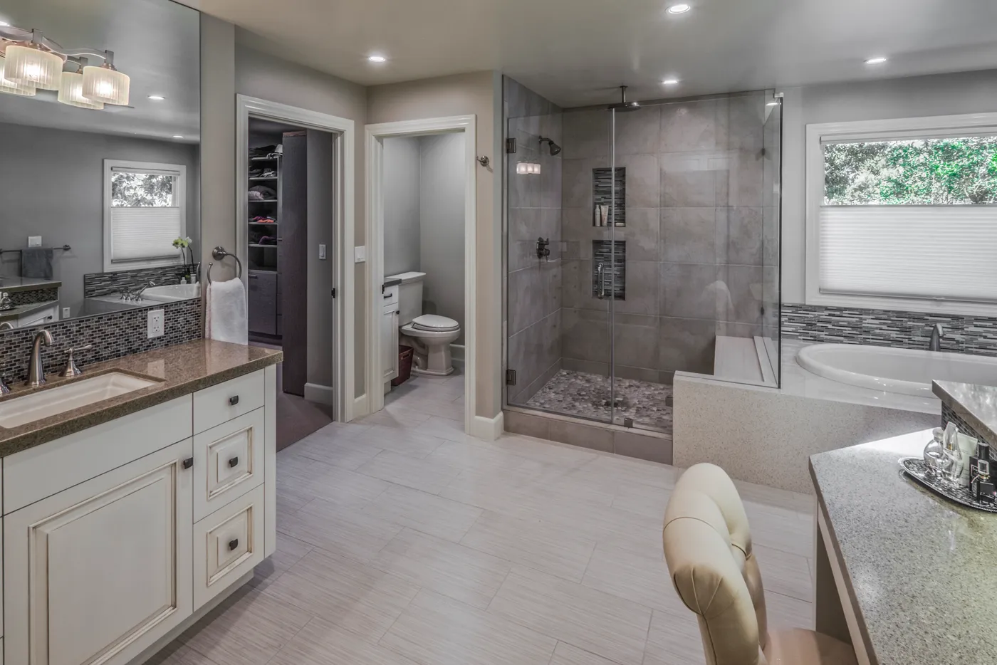 Primary bath with a walk-in shower, corner tub and vanity, dressing room beyond